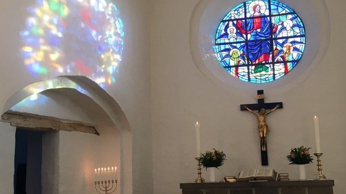 Kapel med farverige vinduer og alter med lysstake