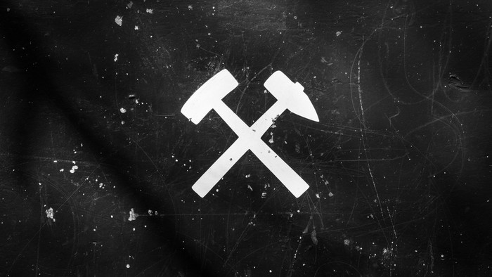 Das Bild zeigt das Symbol des Bergbaus, Hammer und Schläger, auf schwarzem Hintergrund
