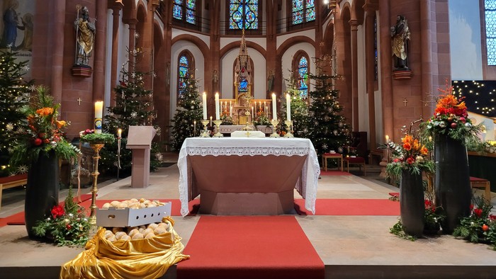 Kircheninneres mit Altar, Buntglasfenstern und Weihnachtsdekoration.