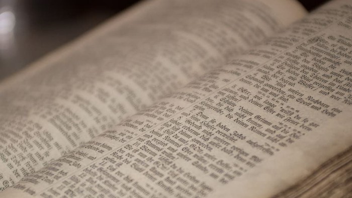 Offenes Buch mit altem Papier und kleiner Schrift
