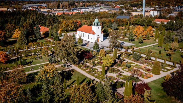 En park med en kirke og en del af en by i baggrunden