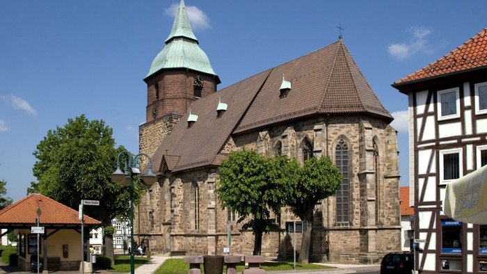 Kirche mit grünem Turmhelm und umliegenden Gebäuden