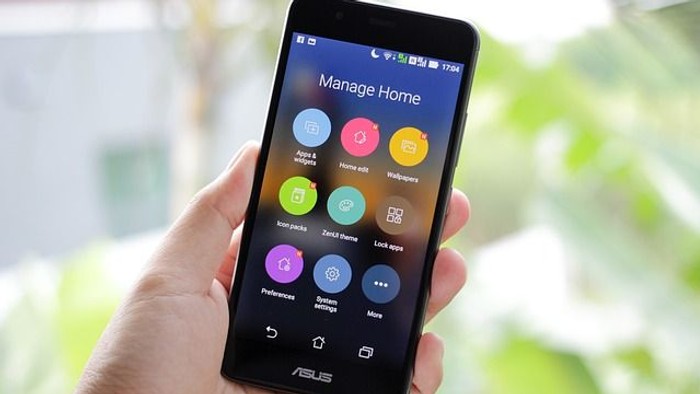 Hand hält ein schwarzes ASUS-Smartphone mit farbenfrohem Startbildschirm