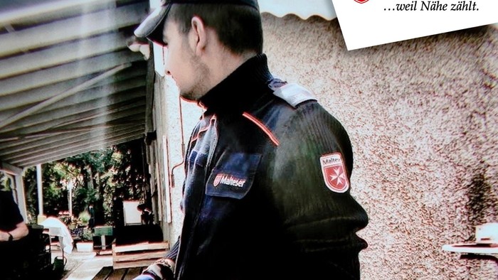 Polizist in Uniform mit einer Waffe in der Hand, mit deutschem Text