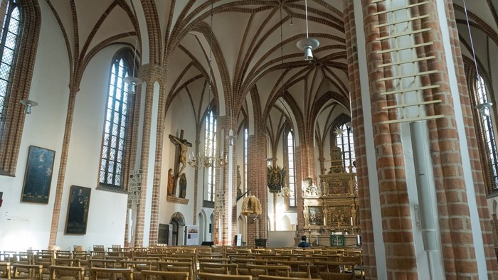 Großzügige Kircheninneraum mit hohen Bögen und Buntglasfenstern