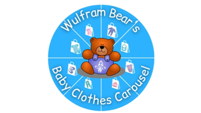A teddy bear on a baby clothes carousel, surrounded by various baby items