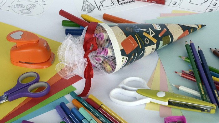 Buntstifte, Scheren und Bastelpapier auf einem Tisch