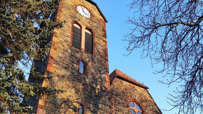 Gotische Kirche mit hohem Turm und Uhr.