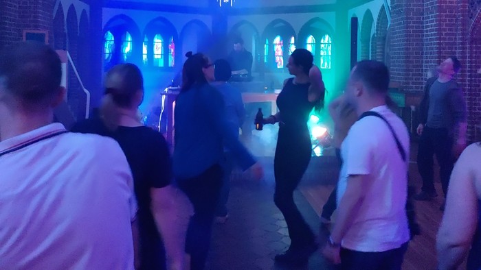 Tanzende in der blau ausgeleuchteten Dreifaltigkeitskirche