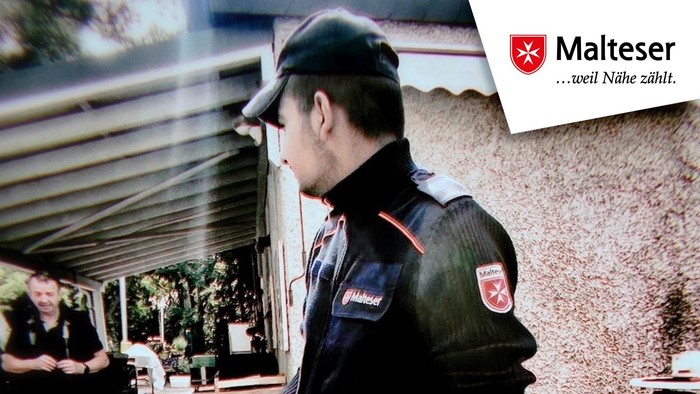 Polizist in Uniform mit einer Waffe in der Hand, mit deutschem Text