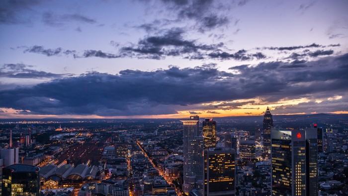 Stadtlandschaft bei Dämmerung mit Wolken und beleuchteten Gebäuden