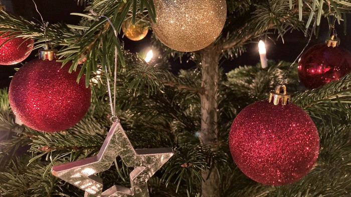 Ein Weihnachtsbaum mit roten und goldenen Kugeln und einer Sterndekoration