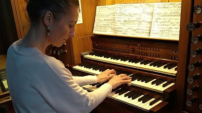 Kvinde spiller orgel i kirke