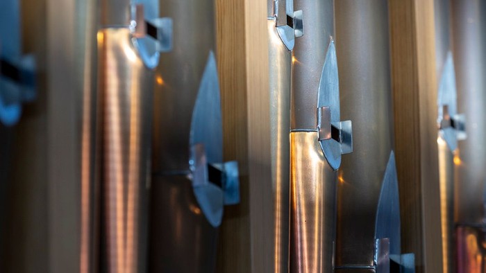 En række skarpe knive på en vegg