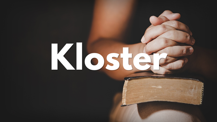 Hände über einem geöffneten Buch gefaltet, im Hintergrund ist das Wort „Kloster“ deutlich zu sehen.