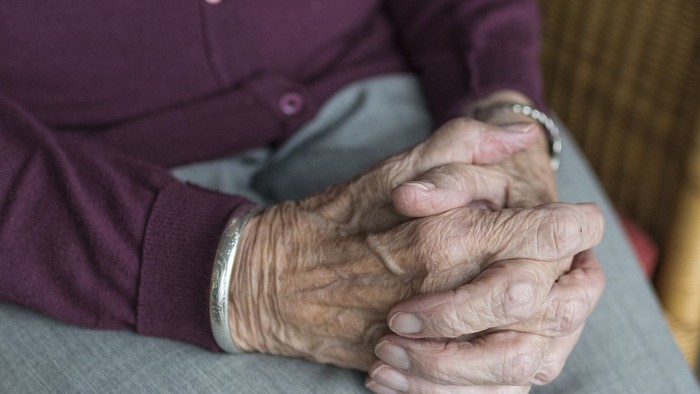 Hände einer älteren Person mit Armband und Uhr