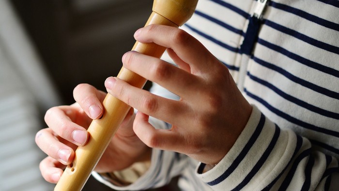 Kind spielt mit gelben Holzstöcken