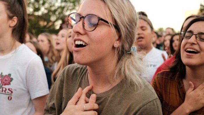 Eine Gruppe von Menschen singt gemeinsam unter freiem Himmel.
