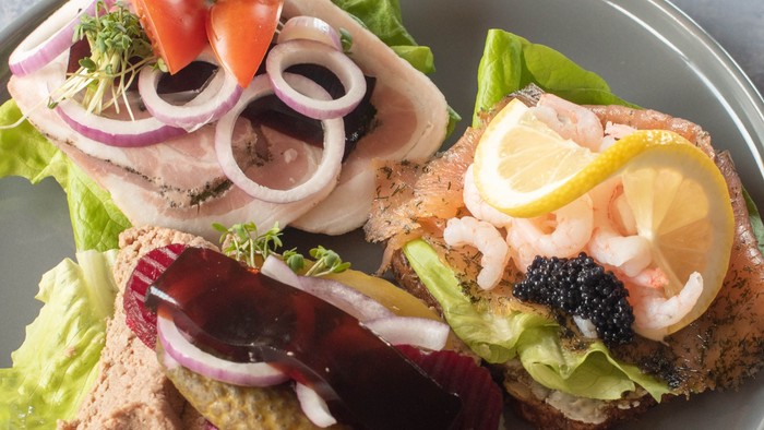 En smørrebrød med roastbeef, rødløg og rødko.