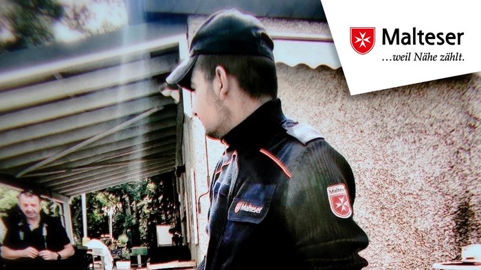 Polizist in Uniform mit einer Waffe in der Hand, mit deutschem Text