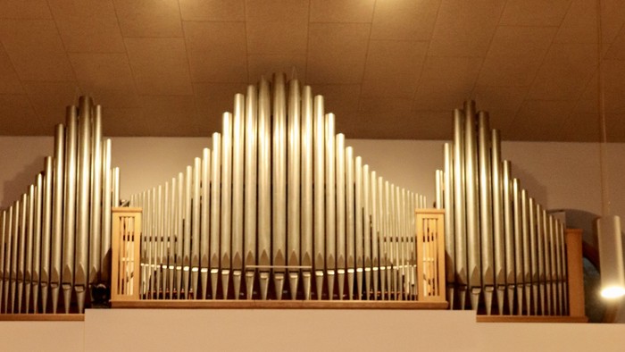 Orgel in Kirche mit Kreuz und Blumen
