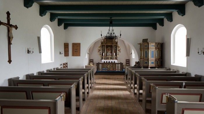 Indre del af kirke med alter og bænke.