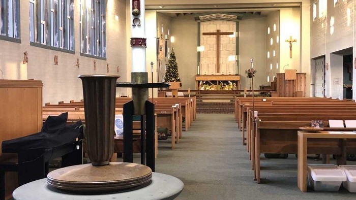 The interior of St Francis Church with the font and paschal candle in the foreground.