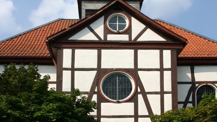 Außenansicht der evangelischen Kirche in Gieselwerder. Fachwerkfassade mit rotem Ziegeldach.