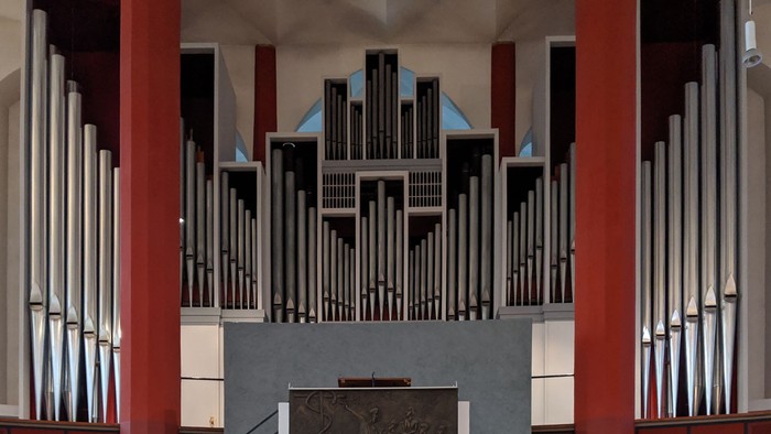 Orgel in Kirche mit farbenfrohem Gehäuse und Relief