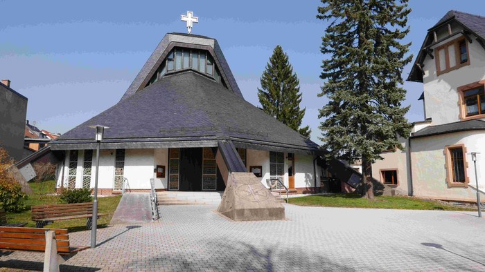 Kirchhof mit Kirche, Bäumen und Bänken