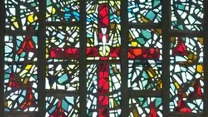 Buntes Kirchenfenster mit rotem Kreuz