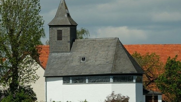 Weißes Gebäude mit rotem Dach und kleinem Turm.