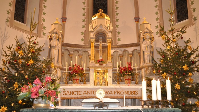 Gepflegte Kirchenaltäre mit Blumen und Kerzen