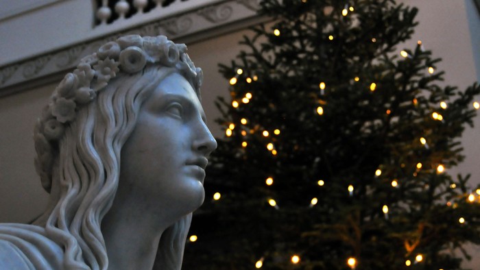 Statue foran juletree med lys