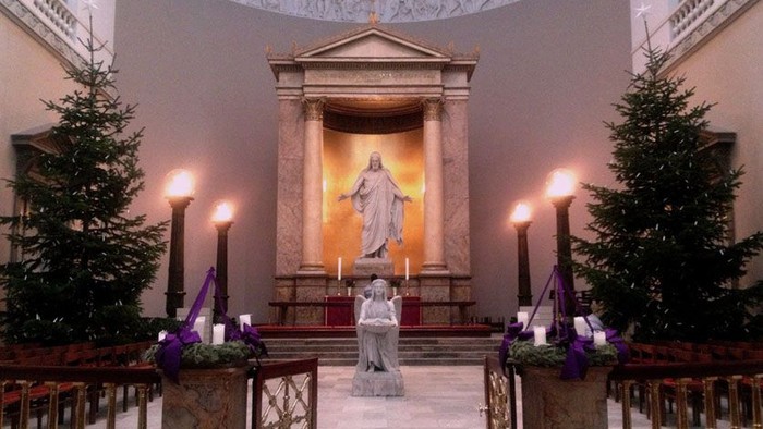 Indre del af kirke med julestænder og statue af Jesus