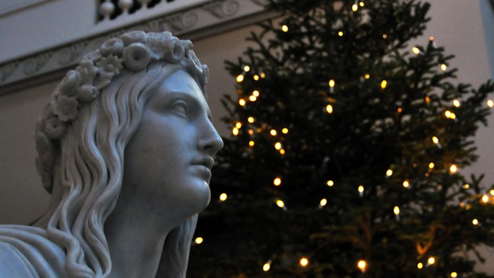 Statue foran juletree med lys