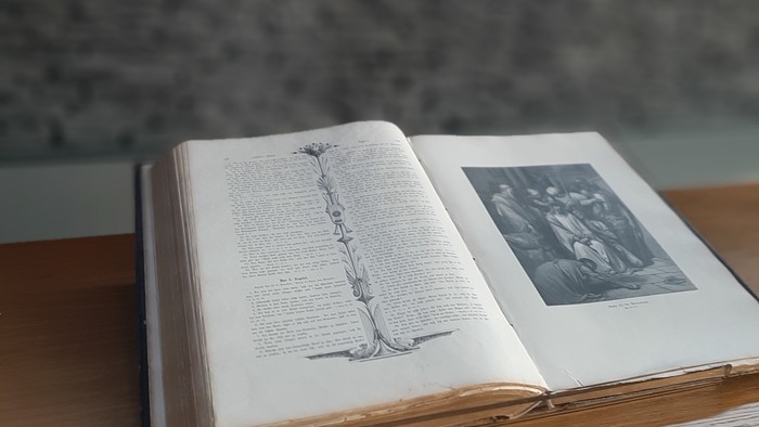 Offenes Buch mit Kreuz im Hintergrund