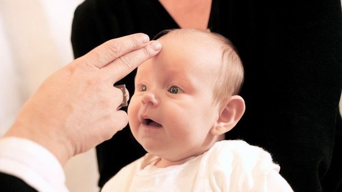En person tager en lille barns temperatur med en termometer.