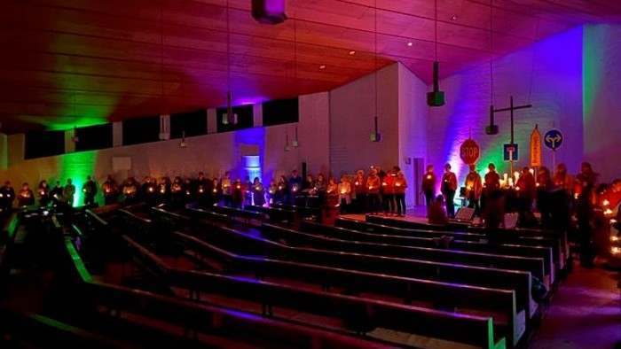 Eine Kirche mit bunten Lichtern und vielen Menschen.