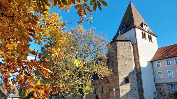 Turm der Stiftskirche in Kaufungen mit herbstlichen Bäumen
