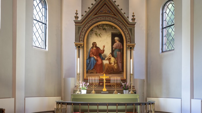 Alter i kirke med maleri og lysstake