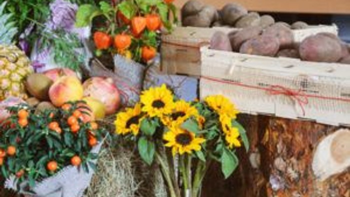 Bunter Obst- und Gemüsestand mit Sonnenblumen