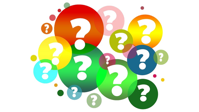 Colorful question marks in various sizes and vibrant hues scattered against a dark background.