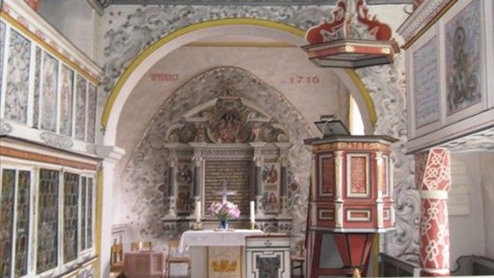 Die Kirche hat einen schönen Altar und hohe Decken.