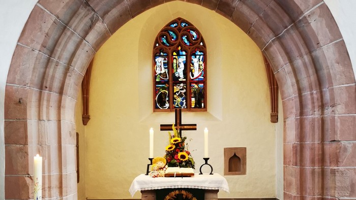 Gotteshaus mit Altar und Buntglasfenster