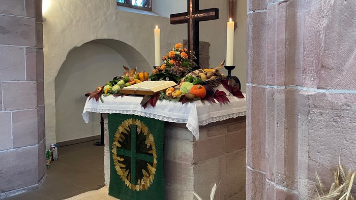 Altar in Kirche mit Kreuz, Kerzen und Blumen