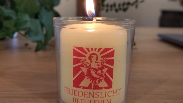 Eine brennende Kerze mit dem Aufdruck 