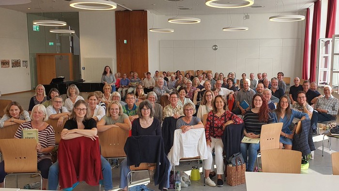 Eine große Gruppe von Menschen versammelte sich drinnen für ein formelles Gruppenfoto oder eine festliche Veranstaltung.