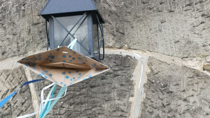 Das Bild zeigt die Eingangslaterne über dem Turmeingang der Margaretenkirche mit Deko von der Konfirmation.