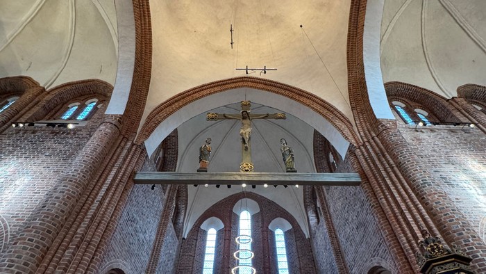 Stor katedralindretning med hvælvede lofter, farvede glasvinduer og prægtige alterudsmykninger.